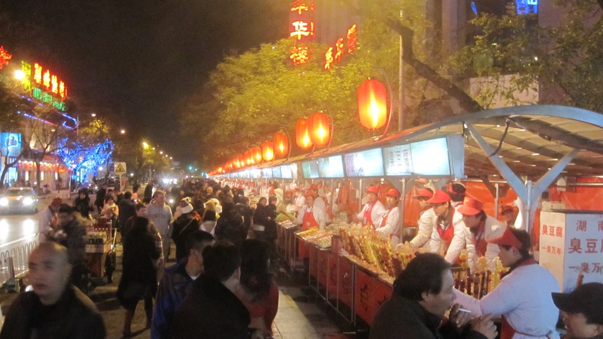 A long line of street food stalls at night in Bejing.