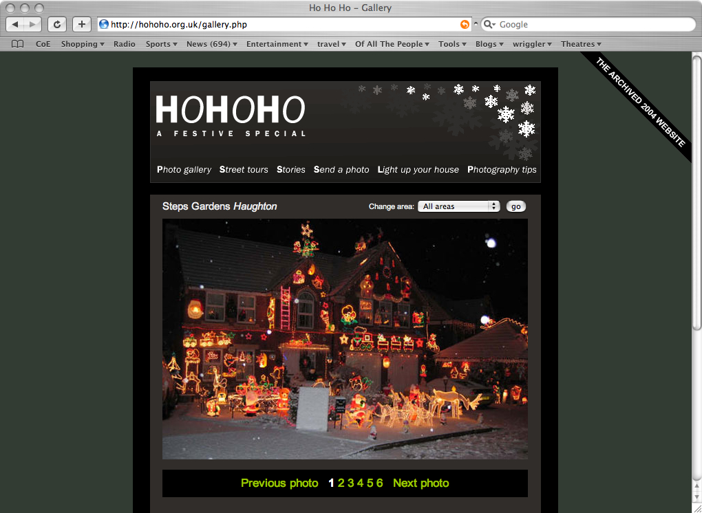 A screedgrab from the HoHoHo website showing a large modern house and its front garden entirely covered in christmas illuminations. It is the night time and there is snow on the ground.